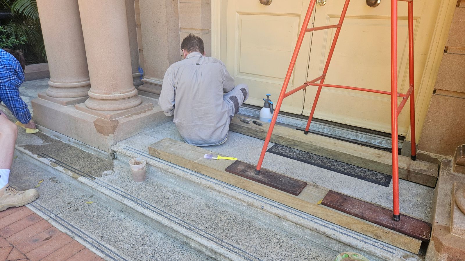 Repair and maintenance work under way at a sandstone-columned heritage entrance porch