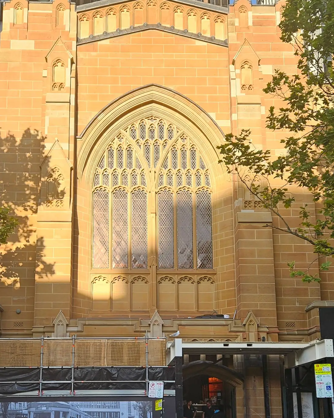 Gothic sandstone church façade in the city with access equipment for restoration